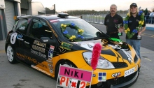 Ники Ланик со своей гоночной машиной с символикой Международного фонда «Молодёжь за права человека» и медалями.